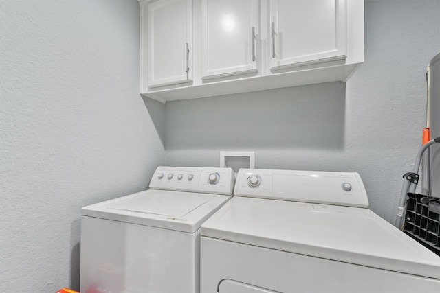 laundry area with washer and clothes dryer and cabinets