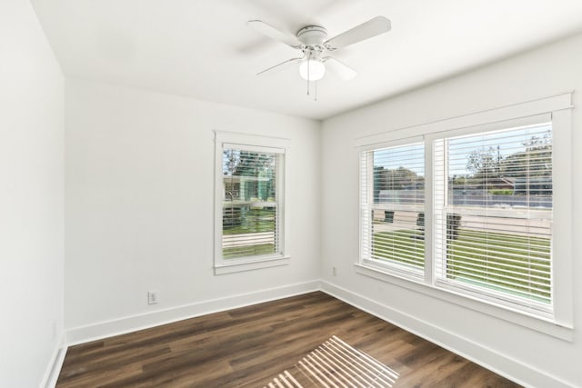 empty room with ceiling fan and dark hardwood / wood-style flooring