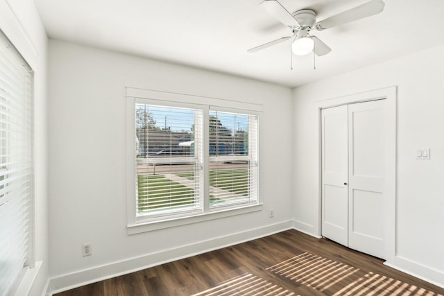 unfurnished bedroom with ceiling fan, dark hardwood / wood-style flooring, and a closet