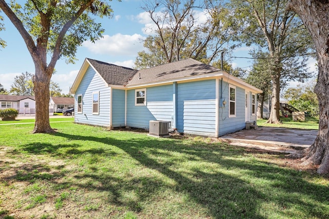 back of house featuring a yard, central AC, and a patio area