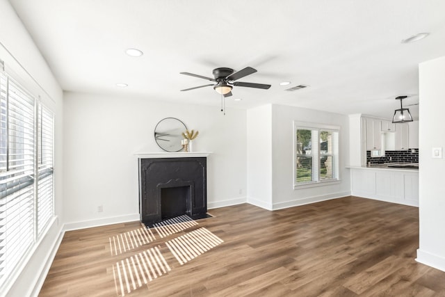 unfurnished living room with ceiling fan and wood-type flooring