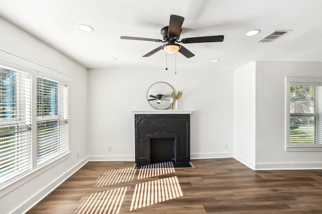 unfurnished living room with dark hardwood / wood-style flooring, ceiling fan, and a premium fireplace