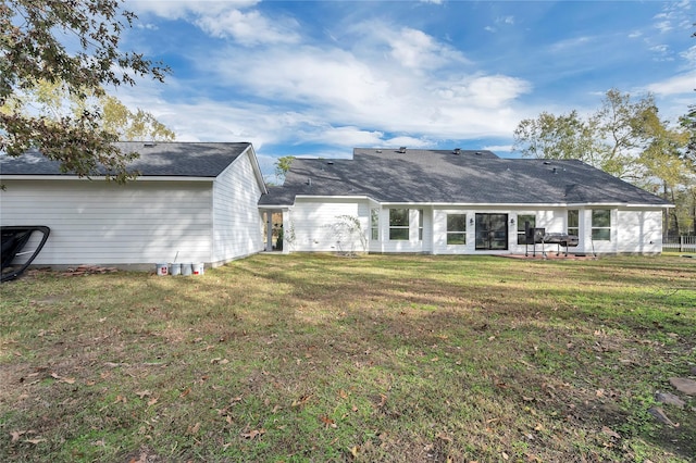 rear view of house with a lawn and a patio area