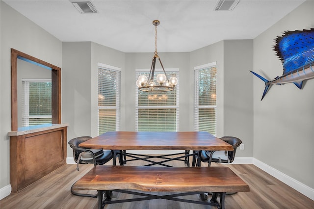 dining space with a notable chandelier and light hardwood / wood-style flooring