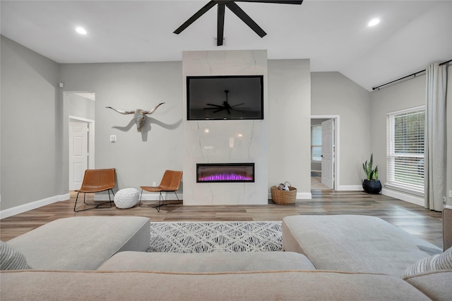 living room with hardwood / wood-style flooring, a fireplace, ceiling fan, and vaulted ceiling