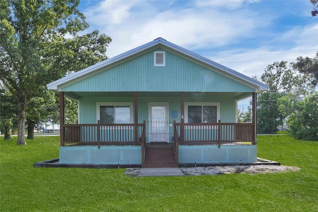 back of house with covered porch and a lawn