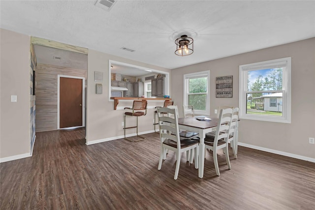 dining space featuring a textured ceiling and dark hardwood / wood-style flooring