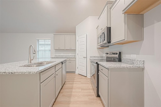 kitchen featuring light hardwood / wood-style floors, a kitchen island with sink, sink, and appliances with stainless steel finishes