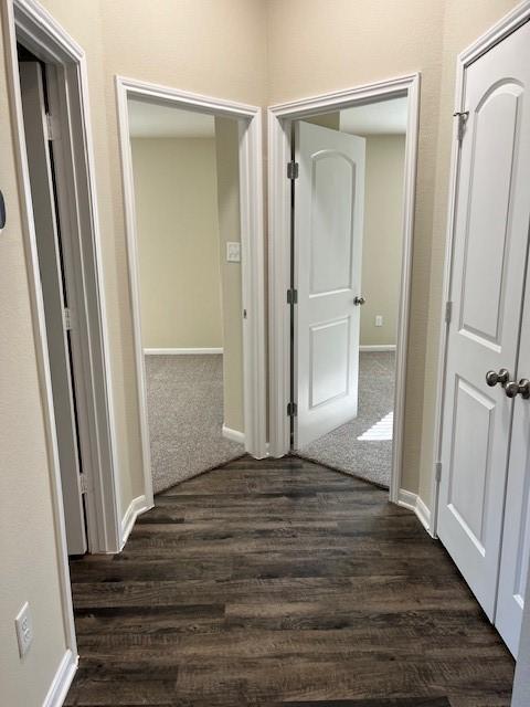 hallway with dark wood-style floors and baseboards