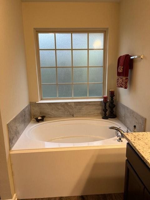 bathroom with a garden tub and vanity