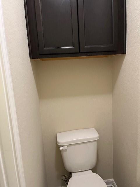 bathroom featuring baseboards and toilet