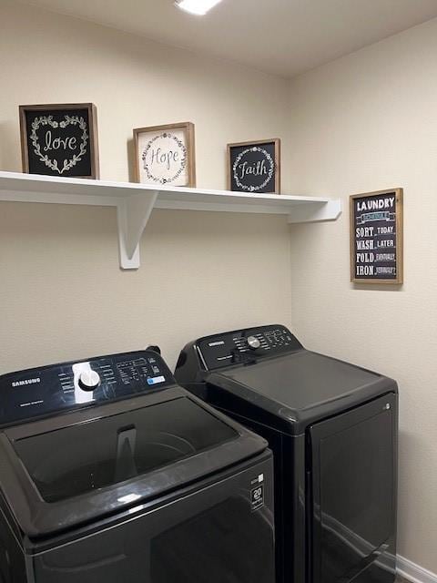 washroom featuring laundry area, washing machine and clothes dryer, and baseboards