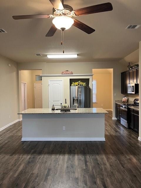 kitchen with stainless steel appliances, a center island, visible vents, and dark wood-style floors