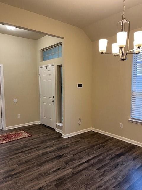 foyer with baseboards, dark wood-type flooring, vaulted ceiling, and an inviting chandelier