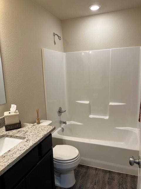 full bath with shower / bathtub combination, vanity, toilet, and wood finished floors