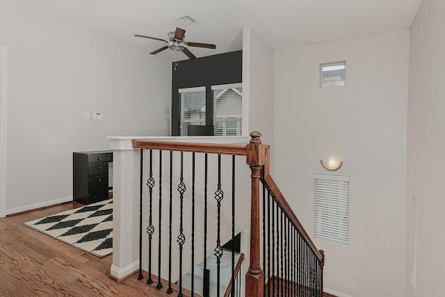 staircase with ceiling fan and wood-type flooring