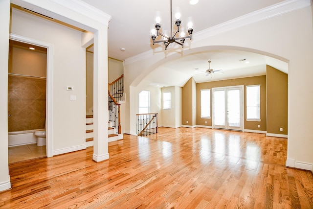 interior space featuring ceiling fan with notable chandelier, french doors, light wood-type flooring, and crown molding