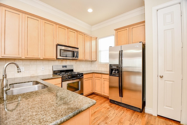 kitchen featuring sink, stainless steel appliances, light stone counters, light brown cabinetry, and ornamental molding