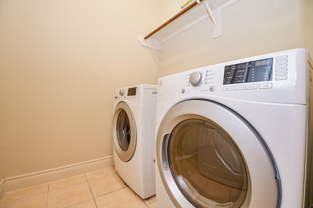 laundry area featuring washing machine and dryer and light tile patterned floors