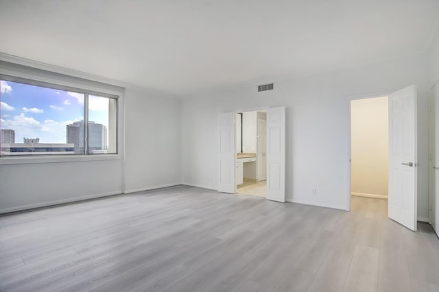 unfurnished room with light wood-type flooring