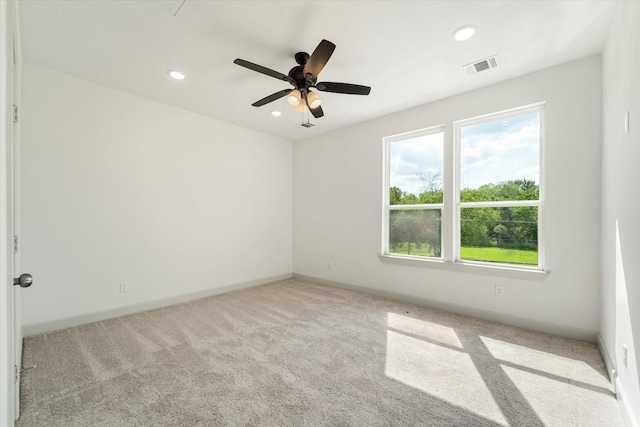 spare room with ceiling fan and light carpet