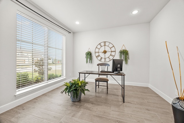 home office featuring light wood-type flooring and a healthy amount of sunlight