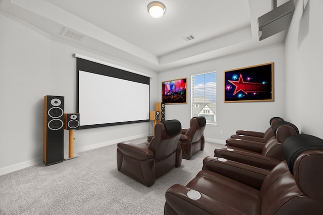 cinema room featuring carpet floors and a raised ceiling