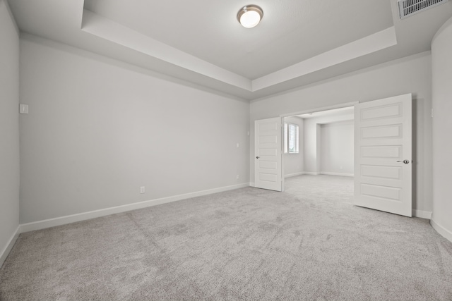 unfurnished room featuring carpet floors and a raised ceiling