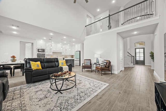 living room featuring a towering ceiling and ceiling fan