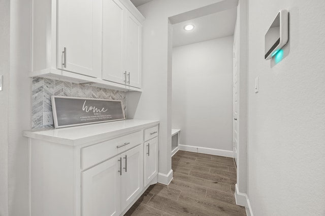 bar with backsplash and white cabinetry