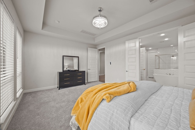 bedroom with a raised ceiling and carpet