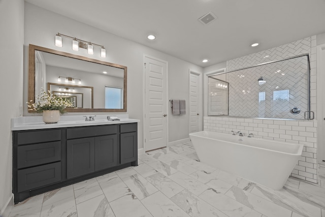 bathroom featuring shower with separate bathtub and vanity