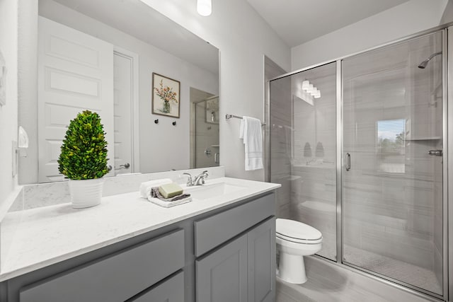 bathroom featuring vanity, toilet, and an enclosed shower