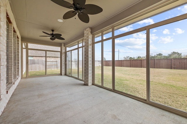 unfurnished sunroom featuring ceiling fan