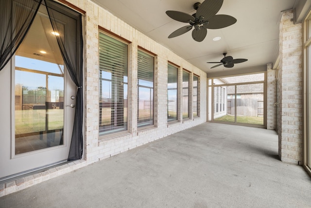 unfurnished sunroom featuring ceiling fan