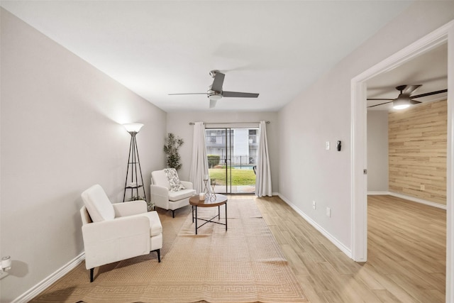 living area featuring light wood-type flooring and ceiling fan