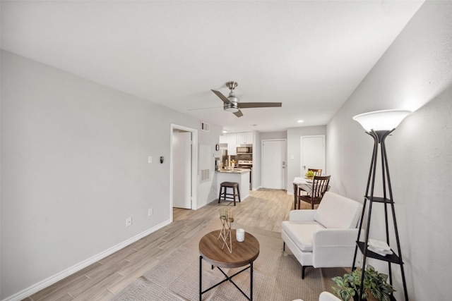 living room with light wood-type flooring and ceiling fan