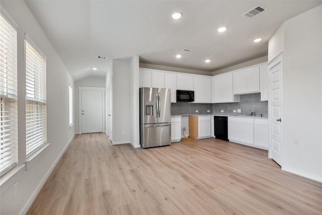 2971 Colonia Blossom Ln, Pinehurst, TX 77362 - kitchen with black appliances, tasteful backsplash, light wood finished floors, white cabinetry, and recessed lighting