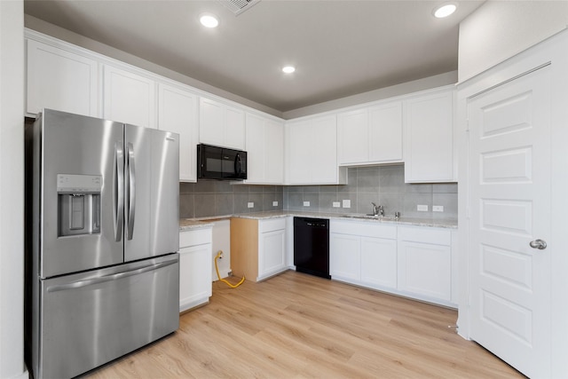 2971 Colonia Blossom Ln, Pinehurst, TX 77362 - kitchen featuring black appliances, backsplash, light wood-type flooring, white cabinets, and recessed lighting