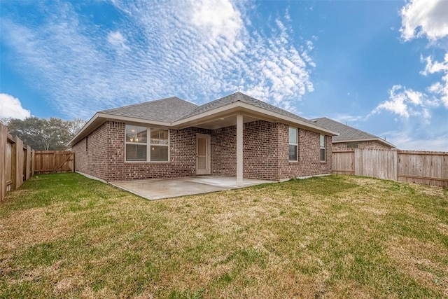 back of property with a yard and a patio