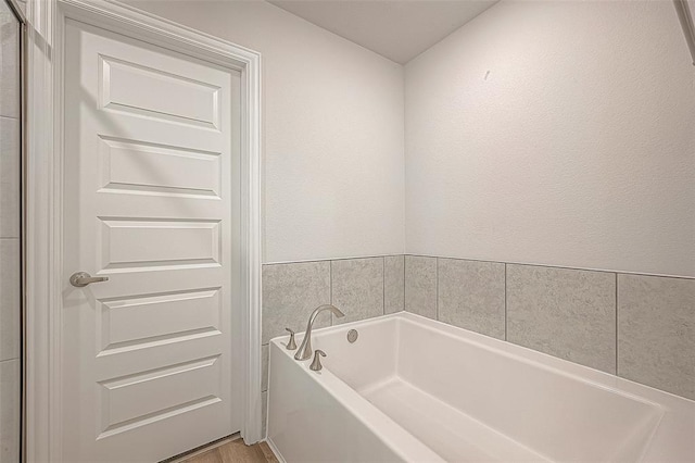 bathroom featuring a washtub and hardwood / wood-style floors