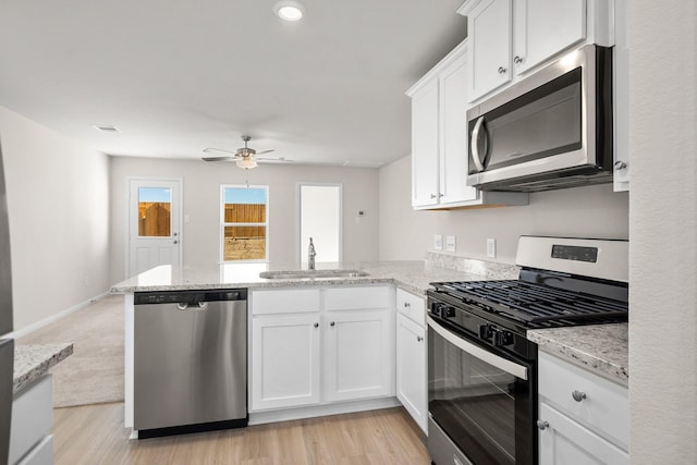 kitchen featuring appliances with stainless steel finishes, white cabinetry, ceiling fan, and sink