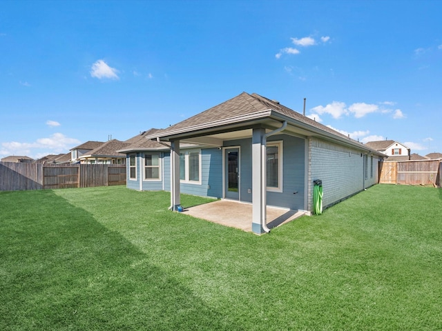 back of property with a yard and a patio