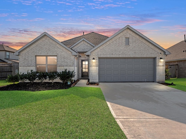 view of front of home with a yard and a garage