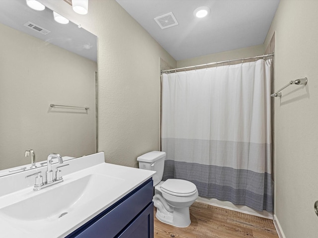 bathroom featuring walk in shower, toilet, vanity, and hardwood / wood-style flooring