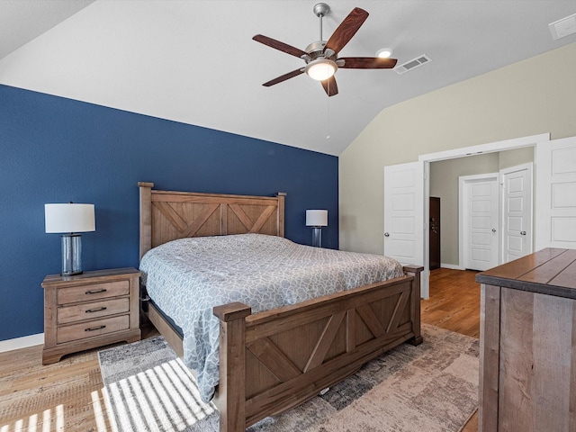 bedroom with ceiling fan, vaulted ceiling, and light wood-type flooring