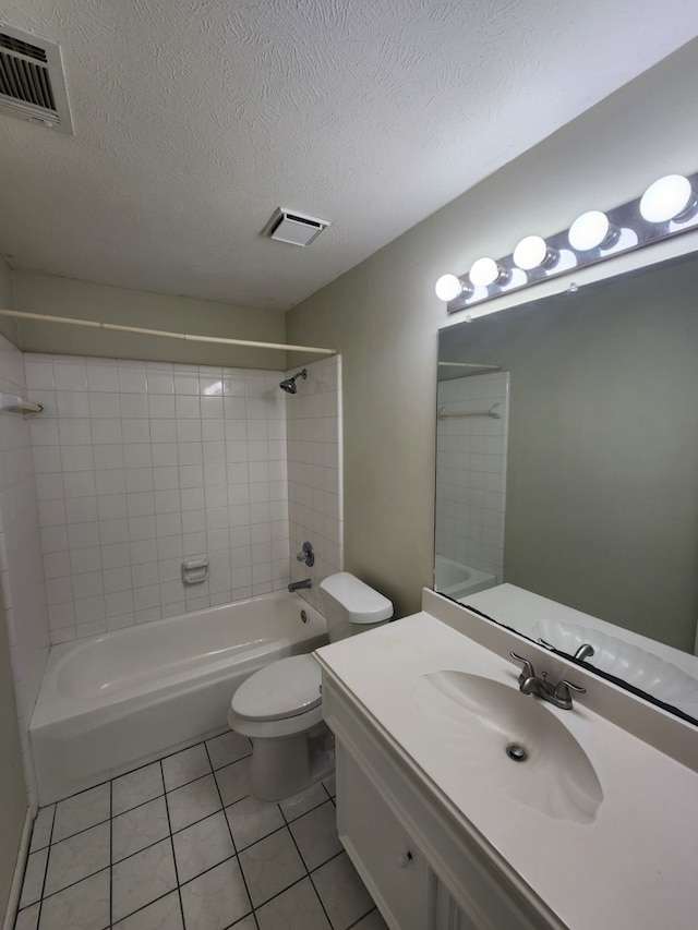 full bathroom featuring vanity, a textured ceiling, tile patterned flooring, toilet, and tiled shower / bath