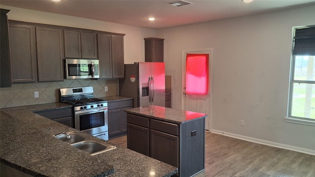 kitchen featuring dark brown cabinets, stainless steel appliances, and a kitchen island