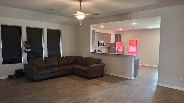 living room with dark hardwood / wood-style floors and ceiling fan