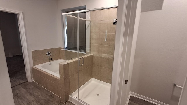 bathroom featuring hardwood / wood-style floors and separate shower and tub